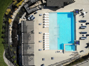 An aerial view of a rectangular pool with a spa and patio by Midwest Custom Pools, LLC in Lawrence, KS.