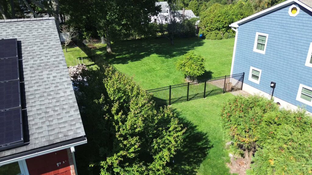 An aerial view of a black aluminum fence enclosing a residential backyard by Quality Fence Inc. in Peekskill, NY
