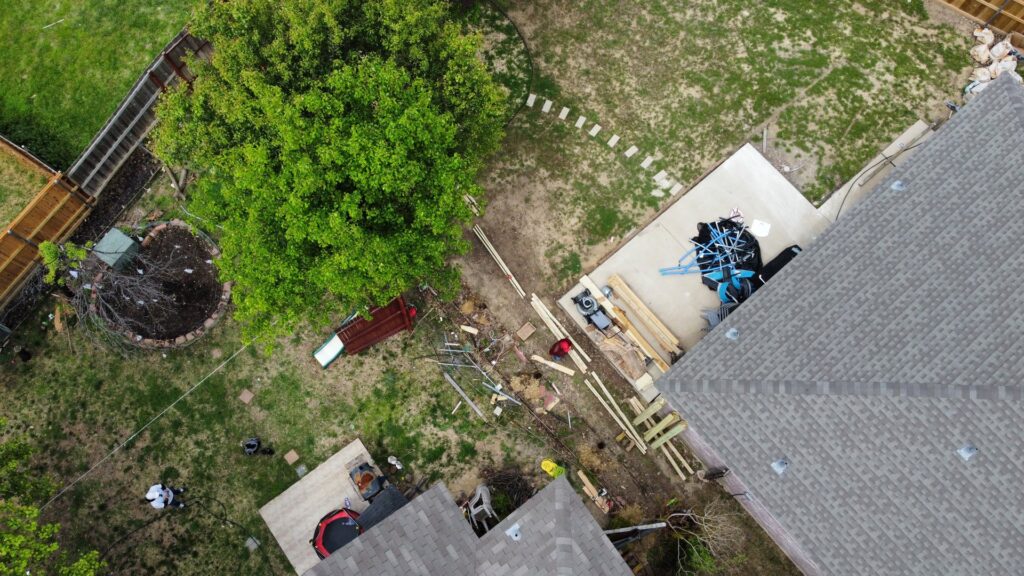 An aerial view of a backyard fencing construction site with lumber and materials, managed by Reliable Texas Fencing in Fort Worth, TX.