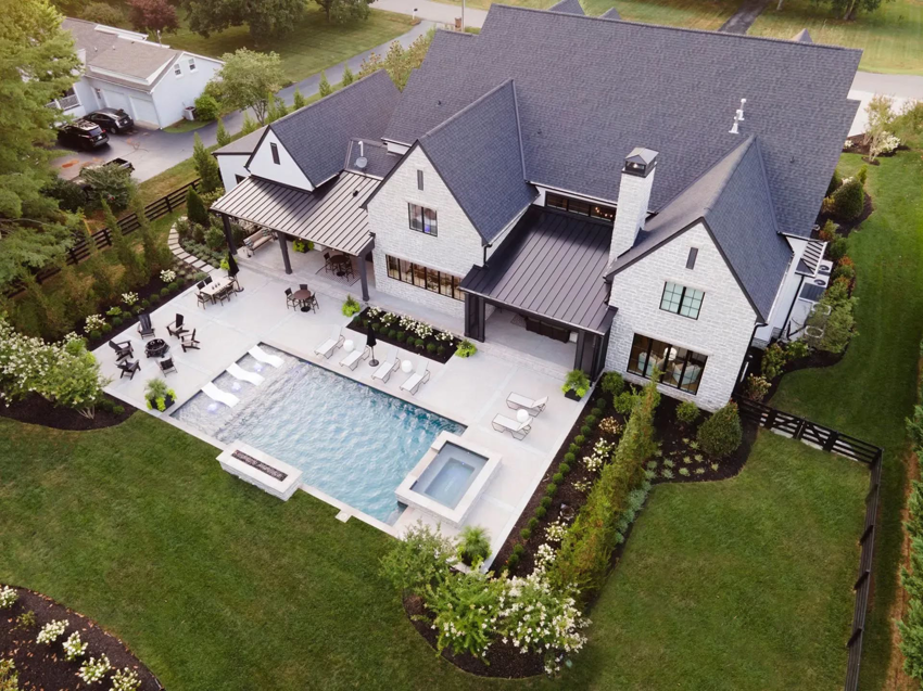 An aerial view of a modern pool and spa with an extensive outdoor living area by Top Tier Pools in Franklin, TN.