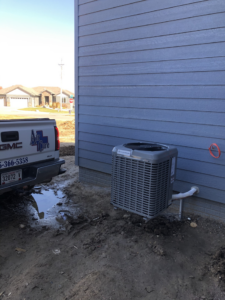 An Air Care service truck parked next to a newly installed outdoor AC unit at a residential property in Sioux Falls, SD.