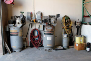 Industrial air compressors in the workshop of Expert Air Conditioning & Heating in Las Vegas, NV, used for HVAC operations.