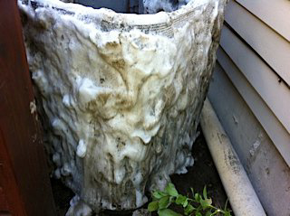 An outdoor air conditioning unit being cleaned with foam by Geddes Heating and Cooling in Aurora, CO.