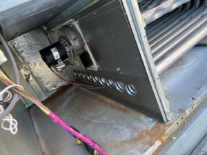 Close-up view inside an air handler unit showing the blower motor and evaporator coils by JM HVAC Pros in Elgin, IL.