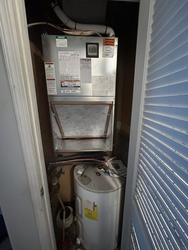 An indoor air handler unit installed in a utility closet by Omega Air Solutions in West Des Moines, IA.