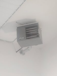 A Modine commercial unit heater installed on a ceiling, representing HVAC services by Aire Serv of Billings, MT.