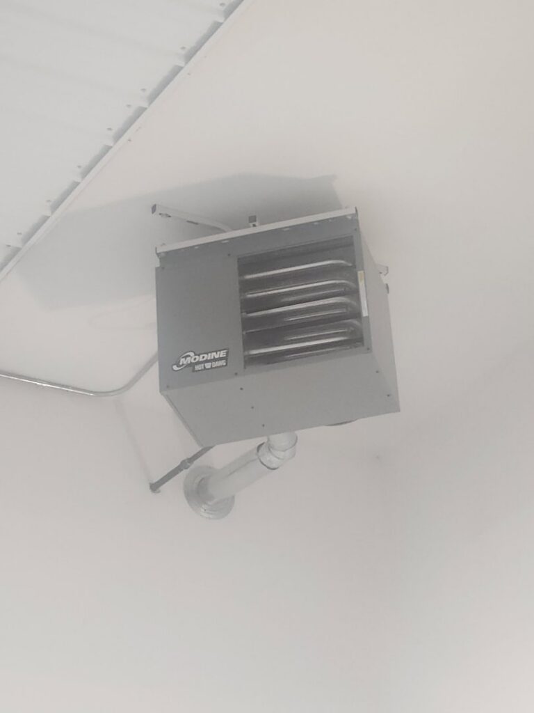A Modine commercial unit heater installed on a ceiling, representing HVAC services by Aire Serv of Billings, MT.