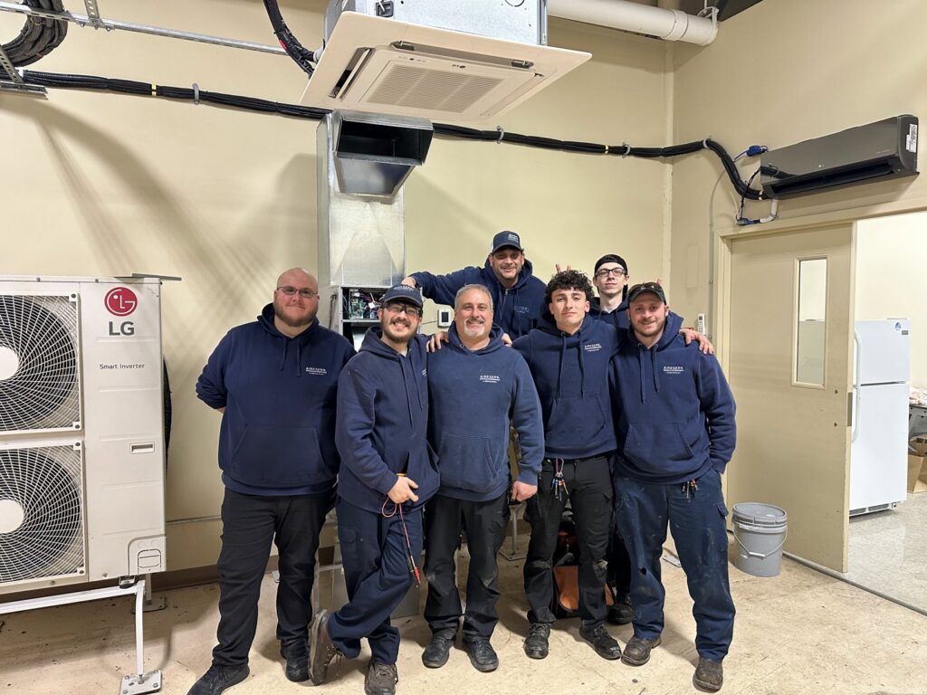 A team of Aire Serv HVAC technicians posing with LG heating and cooling equipment in Rochester, NY