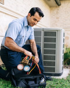 An Aire Serv technician preparing to service an outdoor AC unit, taking tools from a bag in Billings, MT.