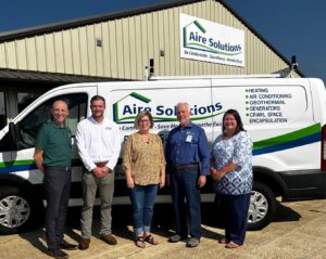 The Aire Solutions HVAC team standing in front of their service van, part of Leap Partners in Greensboro, NC.