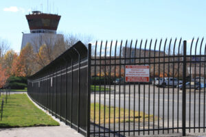 A black metal security fence with a 'No Trespassing' sign at an airport, installed by Life Time Fence, Inc. in Cedar Rapids, IA.