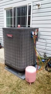 An Airtemp outdoor AC unit undergoing service with refrigerant gauges connected by Allwaysthere Heating and Cooling in Frederick, MD