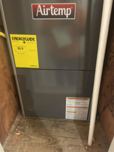 An Airtemp brand HVAC furnace with an EnergyGuide label, installed by Hawthorne Heat & Air in Pollock, LA.
