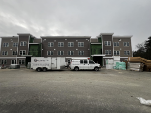 The All Points HVAC service van and trailer parked at a new construction site in Worcester, MA, ready for installation.