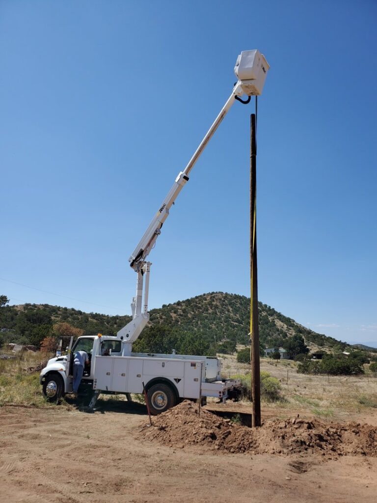 An Allied Electric bucket truck installing a utility pole in a rural area near Sparks, NV.