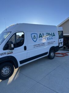 Alpha Clean service van with hoses extended for a professional carpet cleaning job in Fort Wayne, IN.