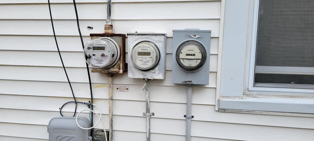 Multiple electrical meters installed on the side of a building, a service provided by Alpha Electric LLC in Dover, NH.