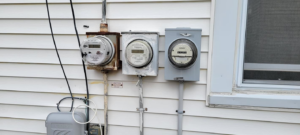 Multiple electrical meters installed on the side of a building, a service provided by Alpha Electric LLC in Dover, NH.