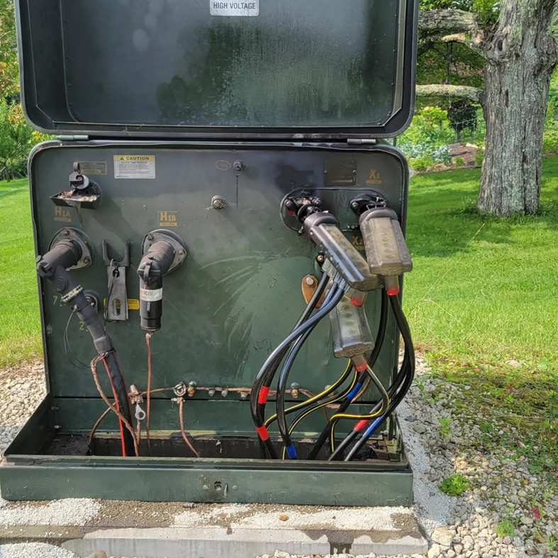 An open electrical transformer box showing internal cable connections, serviced by Alpha Electric LLC in Dover, NH.