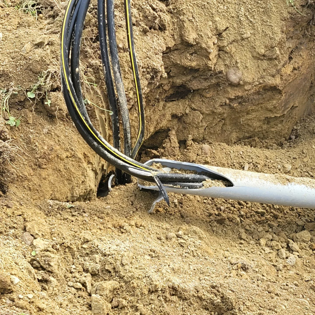 Underground electrical cables emerging from conduit in a trench, part of a project by Alpha Electric LLC in Dover, NH.
