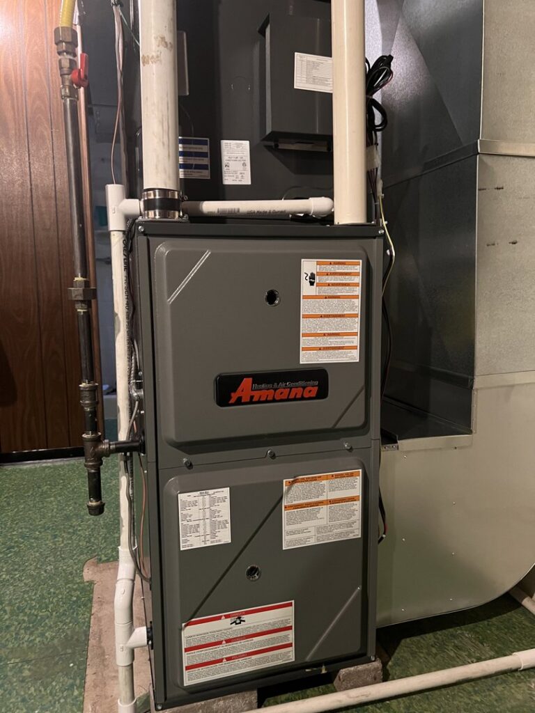 A newly installed Amana furnace and air handler unit in a basement by Service Legends in Des Moines, IA.