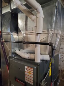 An Amana furnace installation with visible piping and ductwork by Service Legends in Des Moines, IA.