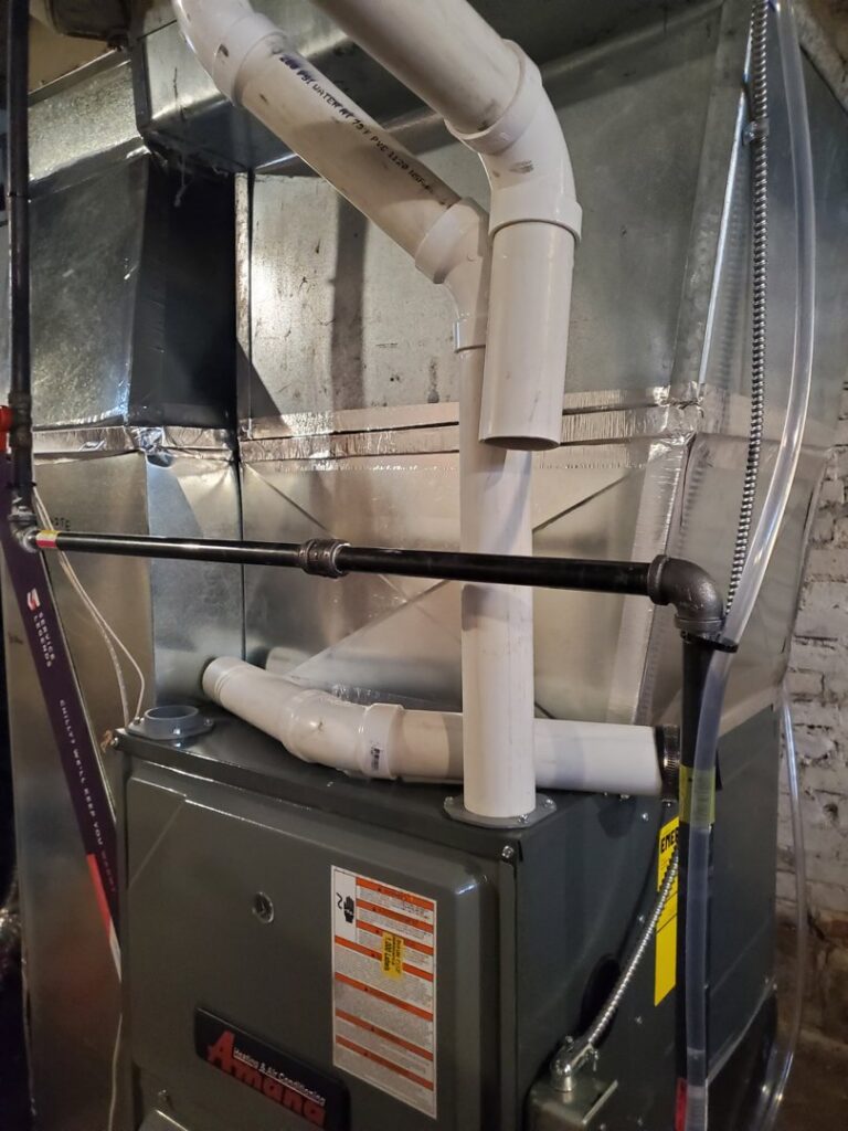 An Amana furnace installation with visible piping and ductwork by Service Legends in Des Moines, IA.