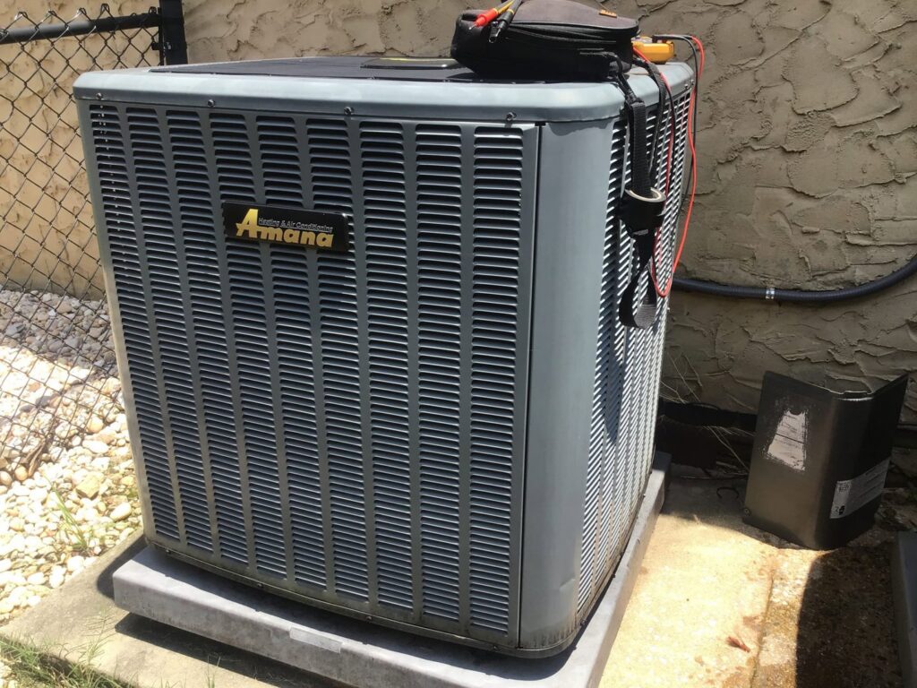 An Amana outdoor HVAC unit undergoing diagnostic testing by a technician from Southern Climate Pros in Jasper, AL.