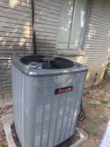 An Amana outdoor air conditioning unit installed next to a brick house by AirTech Solutions LLC in Broken Arrow, OK.