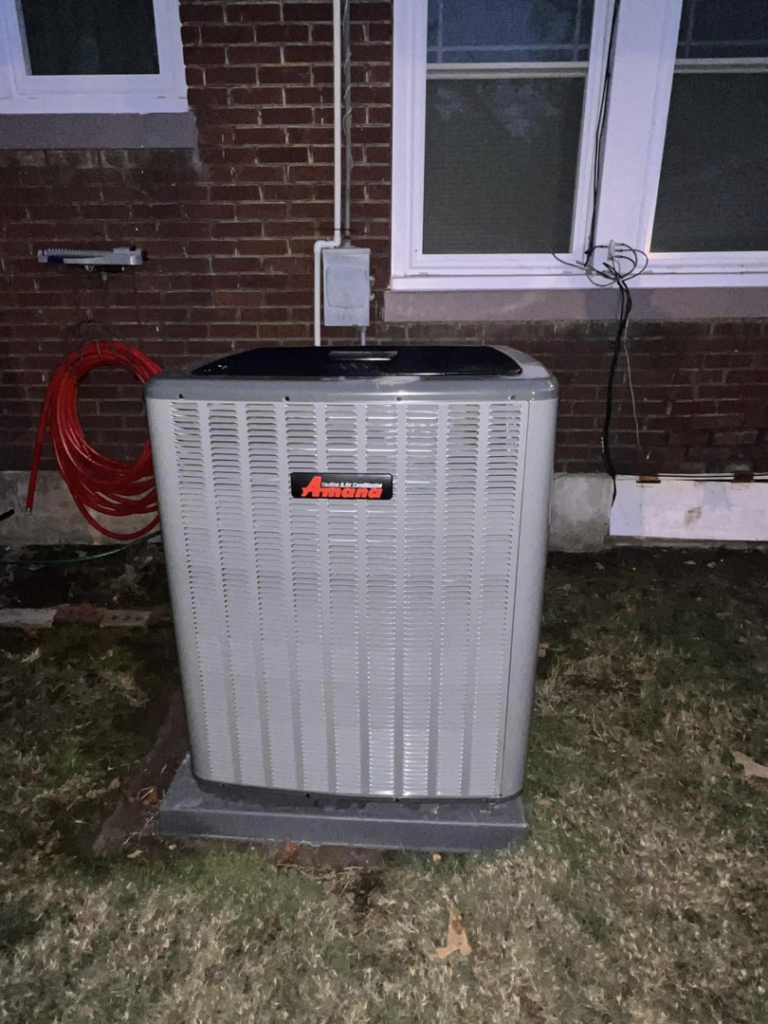 An Amana outdoor HVAC condenser unit installed next to a brick building by Smartcool Inc. in Pine Bluff, AR.