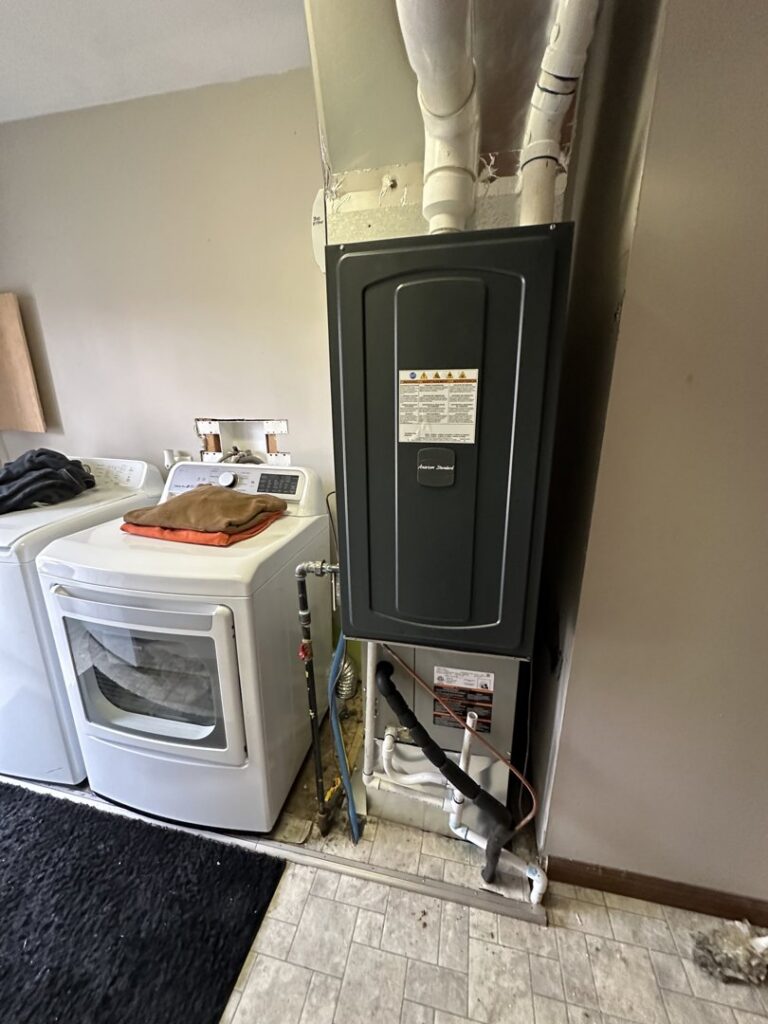 An American Standard furnace unit installed in a laundry room by Breezy Brothers Heating and Cooling in Lafayette, IN.