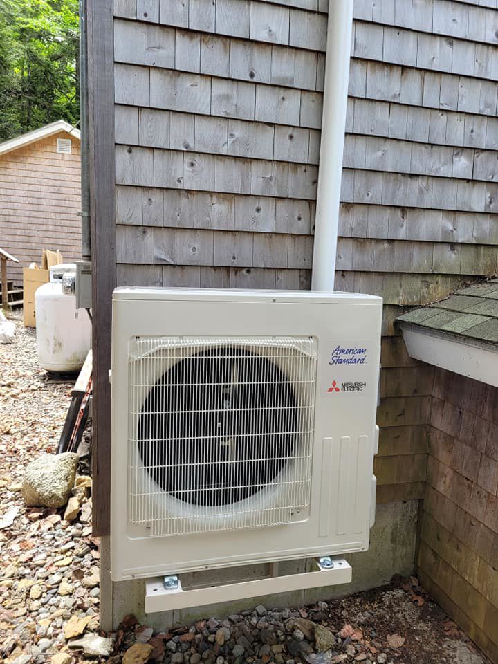 An American Standard Mitsubishi Electric outdoor HVAC unit installed on a shingled home by Maine Thermal Energy Services in Ellsworth, ME