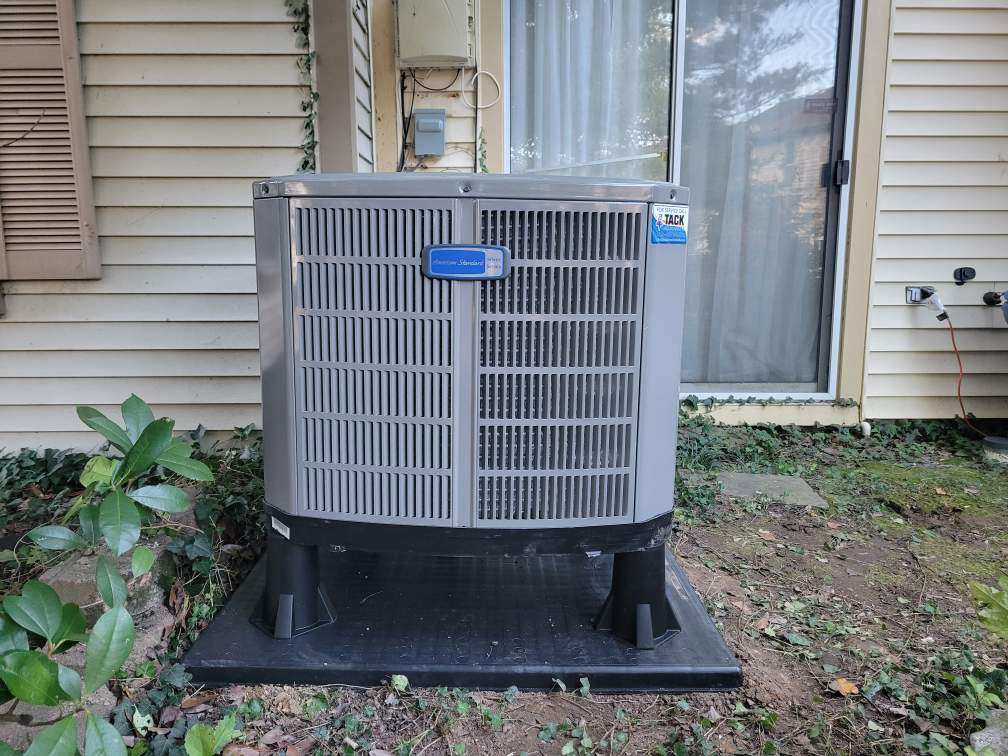 An American Standard outdoor HVAC condenser unit installed next to a home by Tack Mechanical LLC in Baltimore, MD.