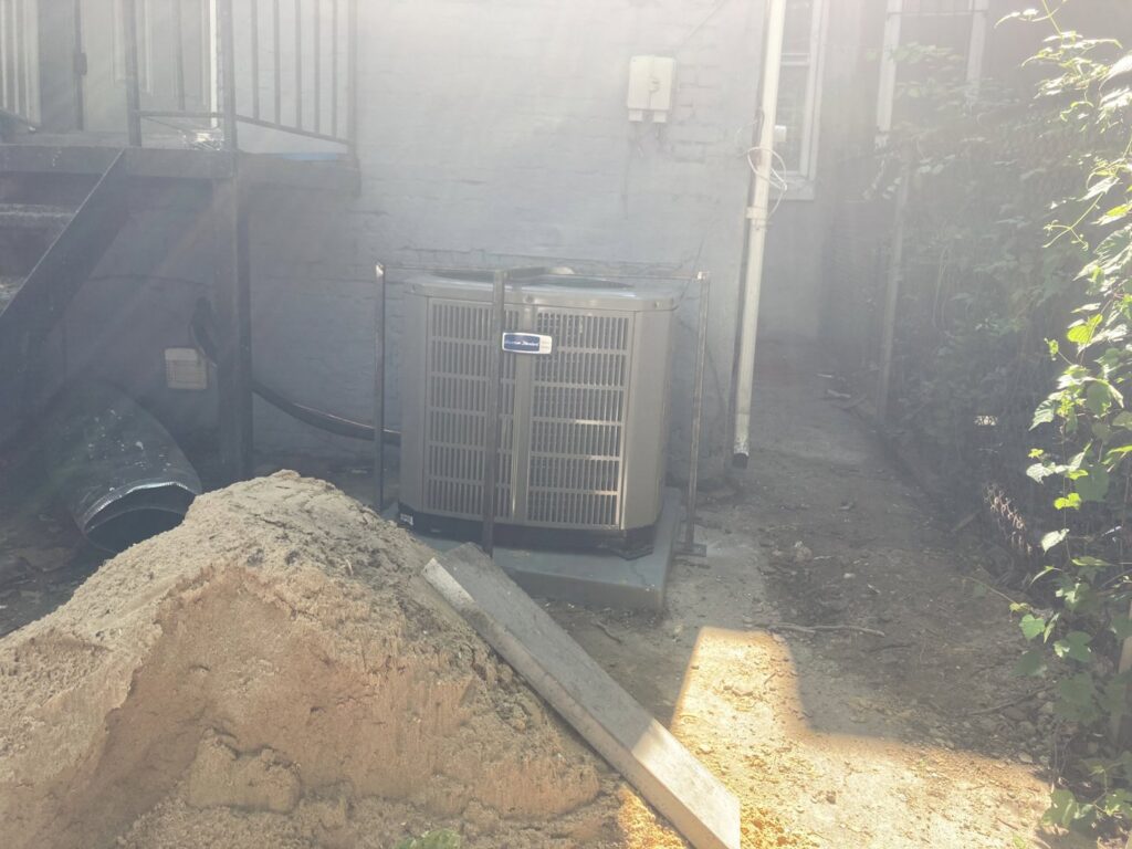 An American Standard outdoor HVAC condenser unit installed next to a building by Tack Mechanical LLC in Baltimore, MD.
