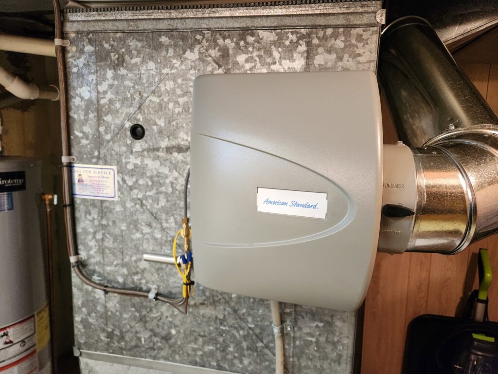 An American Standard whole-house humidifier installed on ductwork by Supertech Home Services to improve air quality in Warren, MI.
