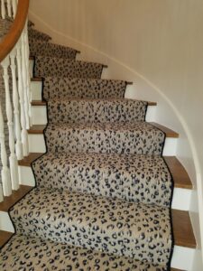 An animal print carpet runner installed on a wooden staircase by Seattle Style Flooring in Seattle, WA.
