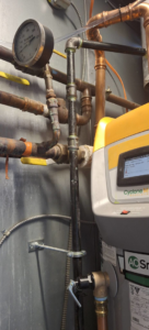 An AO Smith Cyclone M boiler unit with complex piping and gauges, installed by J Hannah Mechanical Inc in Saco, ME.