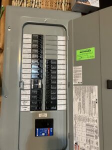 An open electrical panel with labeled circuit breakers and an 'APPROVED' sticker, showing work by J. Bathe Electric in Saint Charles, MO.