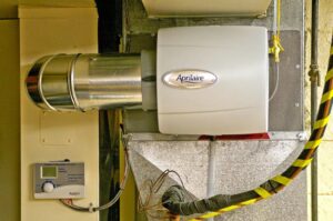 An Aprilaire whole-home humidifier installed on ductwork by Proficient Heating & Cooling in Livonia, MI.