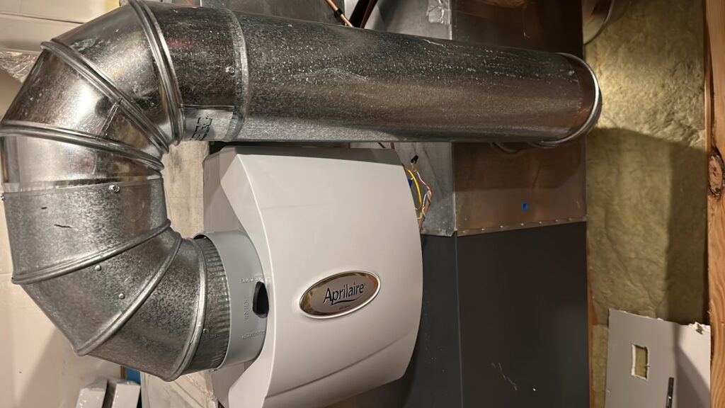 An Aprilaire whole-house humidifier installed with ductwork by Trade Allies Heating and Cooling in Ankeny, IA.