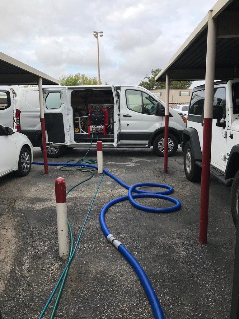Aqualux Carpet Cleaning service van parked at a residential job site with equipment visible in Dallas, TX.