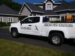 Arbon's Pest Solutions llc truck parked on a residential driveway, providing pest control services in Medford, OR.