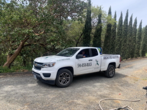 Arbon's Pest Solutions llc branded truck with pest control equipment parked on a gravel driveway in Medford, OR.