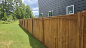 An elegant arched-top wood privacy fence installed next to a modern home by The Fence Guy One in Greenville, SC.