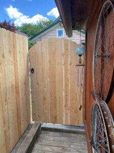 A custom arched wooden gate integrated into a privacy fence by Chisel + Vine in Milwaukee, WI.
