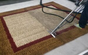 An area rug being professionally cleaned, showing a clear before and after section by Alpine Carpet Care in Medford, OR.