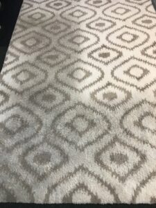 A patterned area rug showing a clear before and after cleaning comparison by Gemini Carpet Cleaning in Lincoln, NE