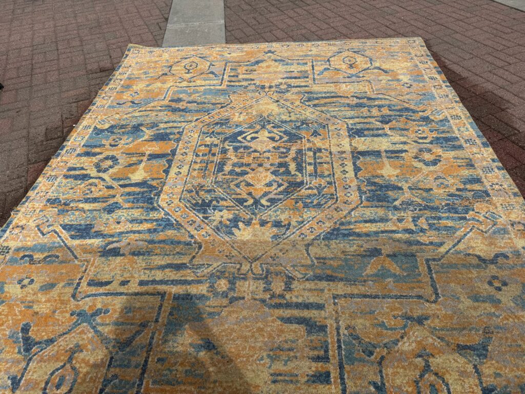 A large patterned area rug laid out for cleaning or drying, part of Captain Clean's services in Muncie, IN.