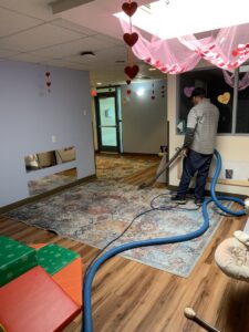 A professional cleaning a large area rug with a carpet cleaning wand at Eagle 1 Carpet Cleaning in Reno, NV.