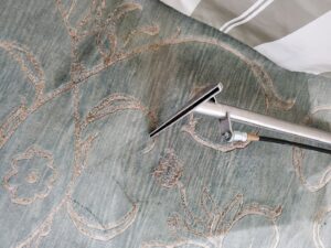 A professional carpet cleaning wand being used to clean a patterned area rug by Genie Clean Services LLC in Dallas, TX.